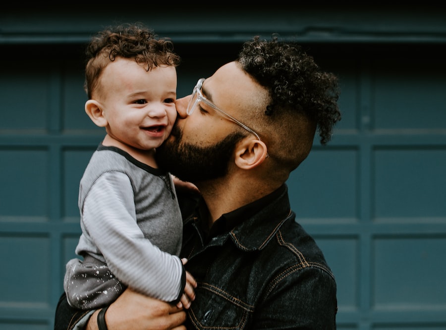 man carrying baby boy and kissing on cheek, dad know parenting tips