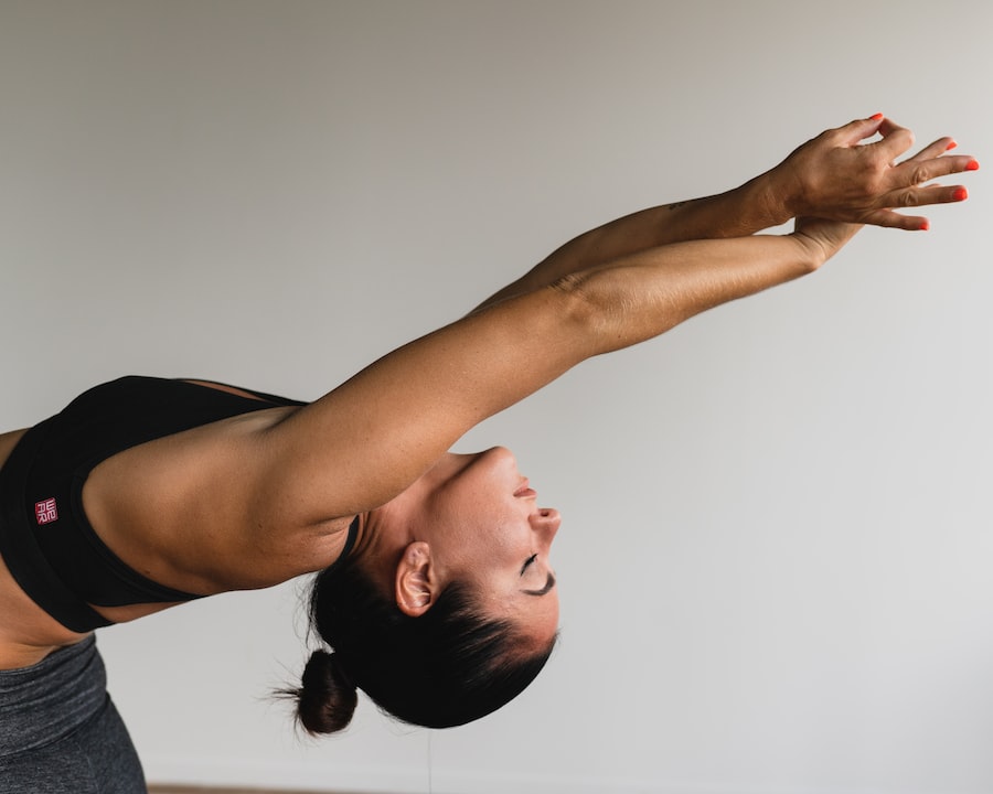 woman stretching arms while doing hatha yoga asanas